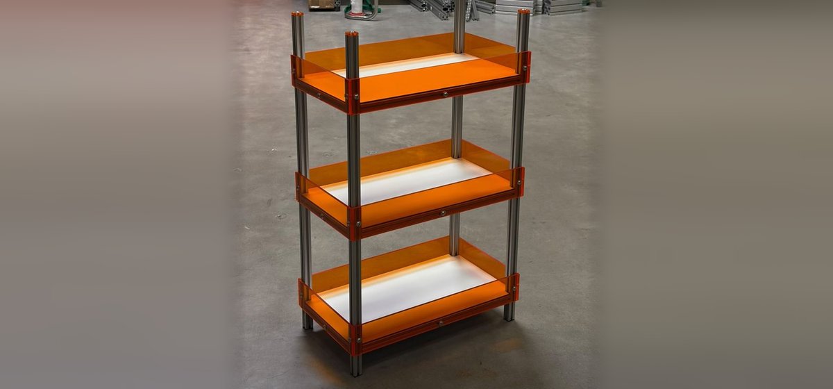 Dreistöckiges Regal aus Aluminiumprofilen mit orangefarbenen Acrylglas-Ablagen